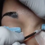 Lash lift course preview: gloved hands applying lifting lotion to lashes on a silicone shield